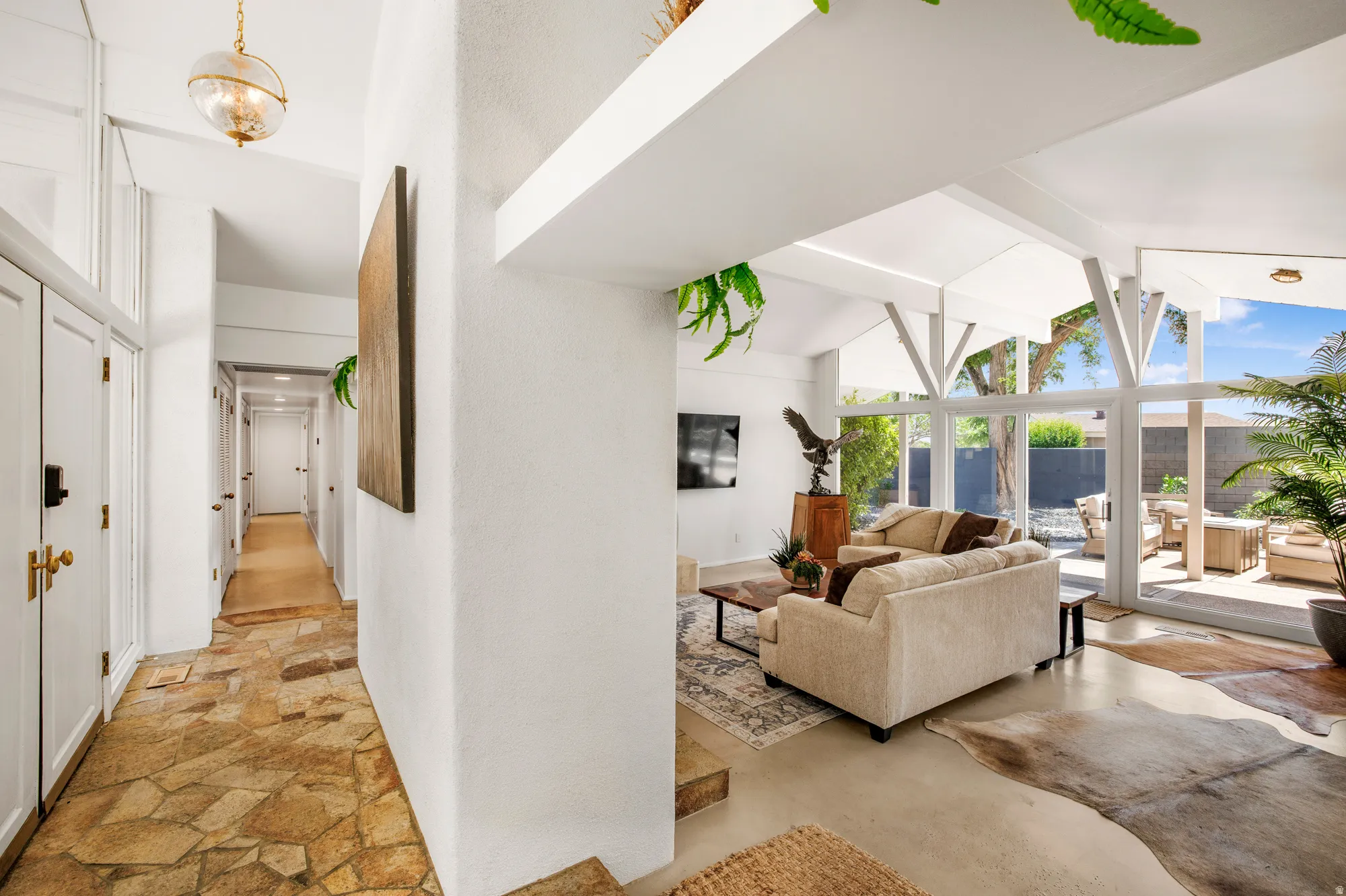Corridor featuring stone finish floors and lofted ceiling