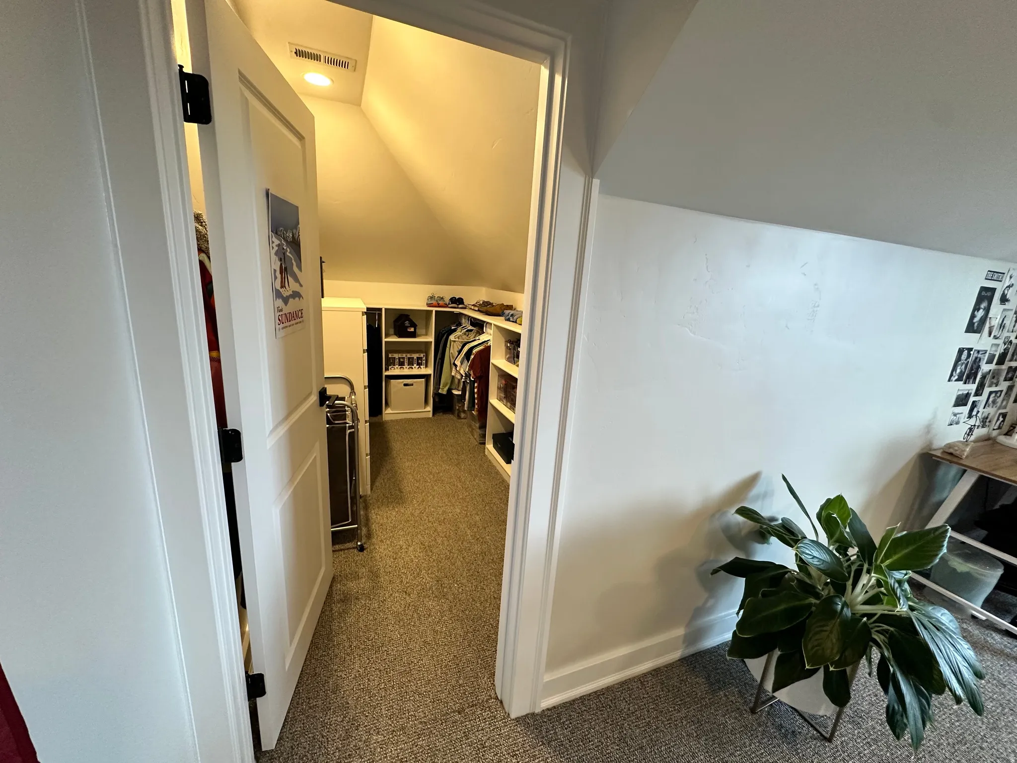 Hallway featuring vaulted ceiling and dark carpet