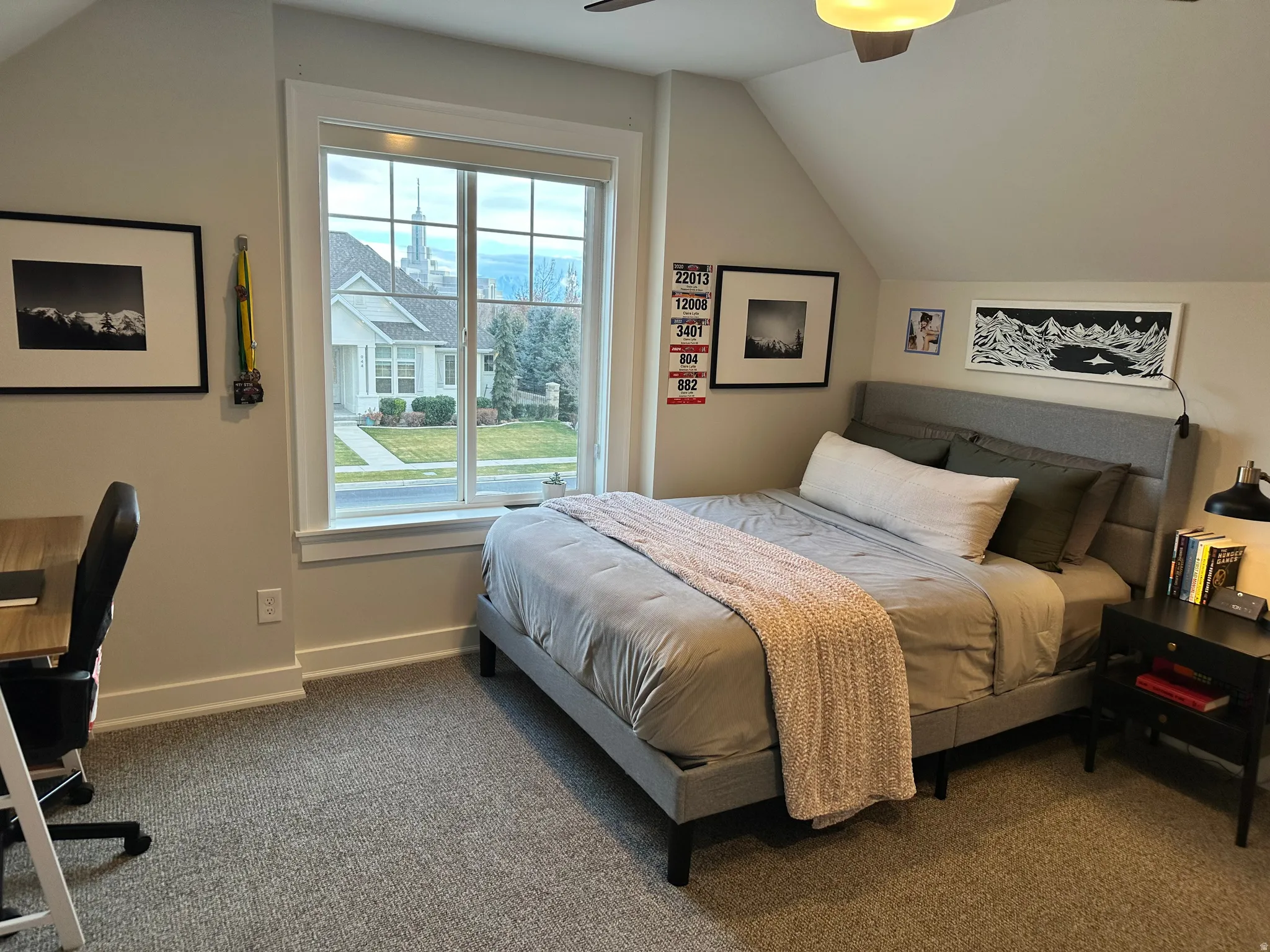 Upstairs Bedroom featuring vaulted ceiling, dark carpet, ceiling fan, and a desk