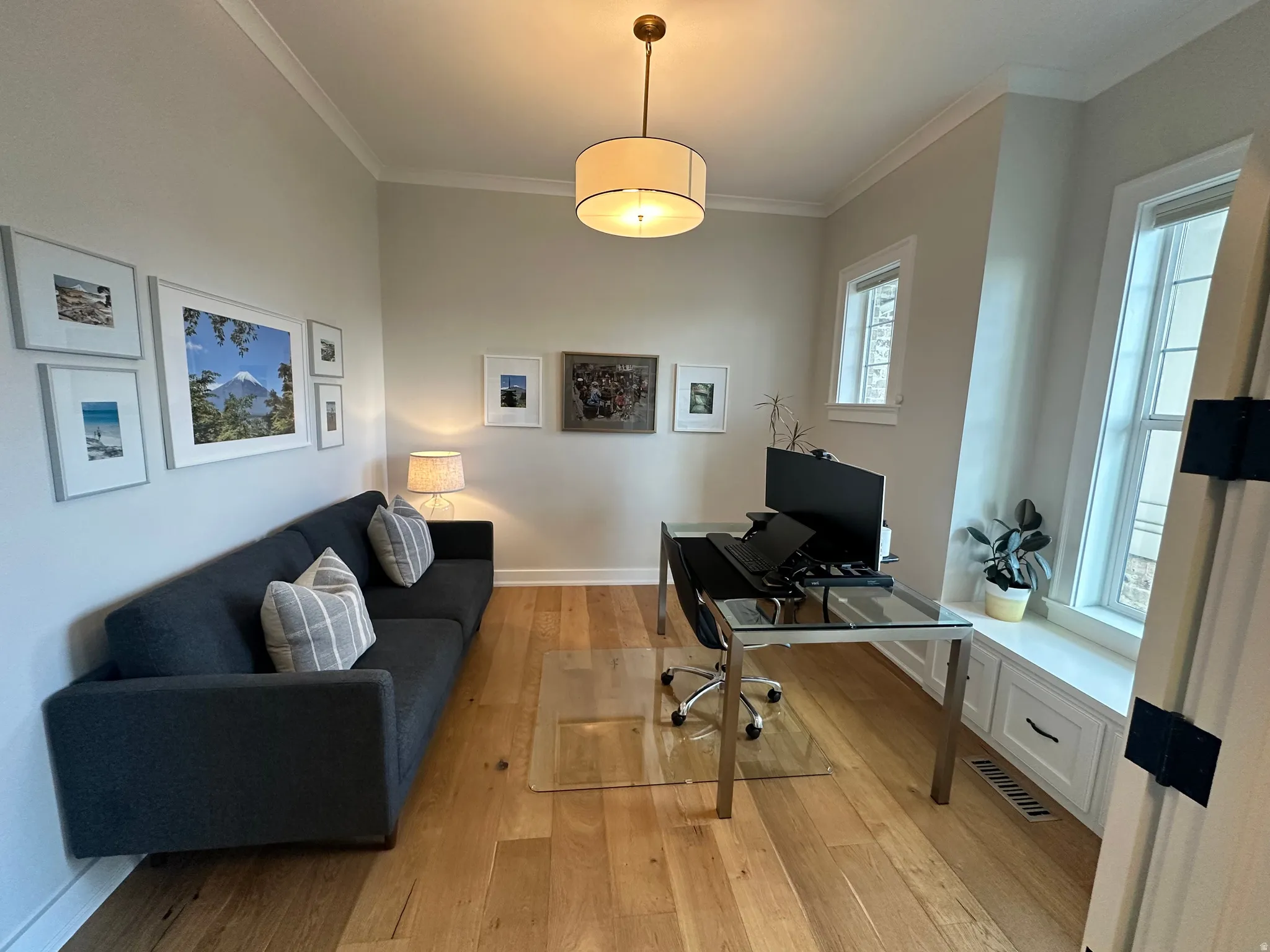 Office area with light wood-style floors and ornamental molding