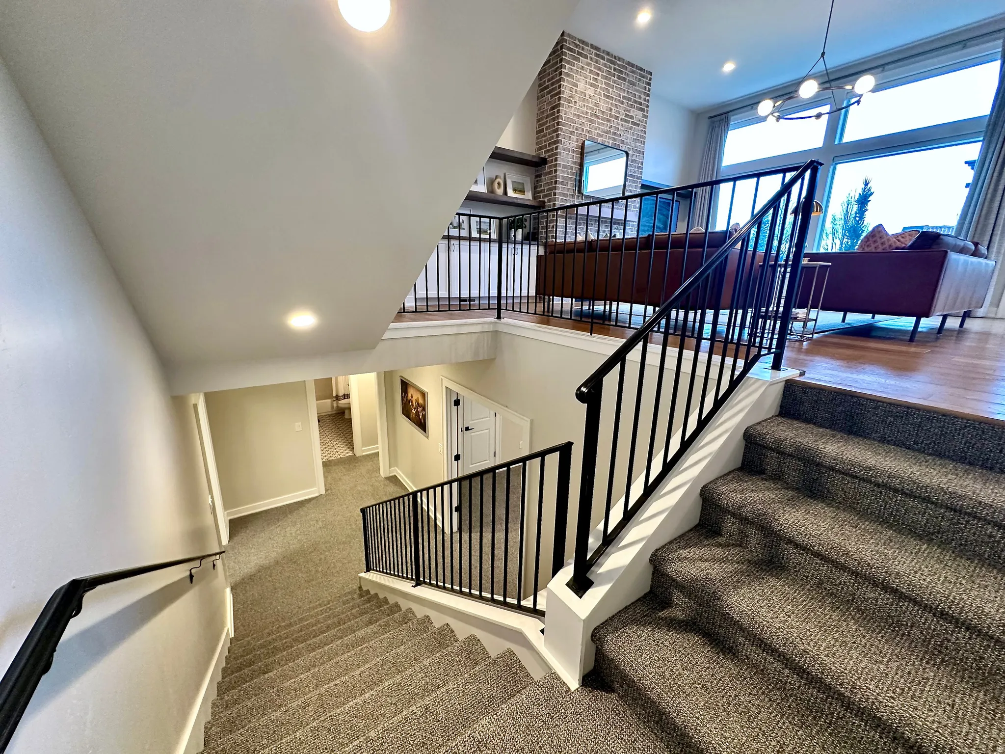Stairway with hanging lights, carpet floors, and a high ceiling