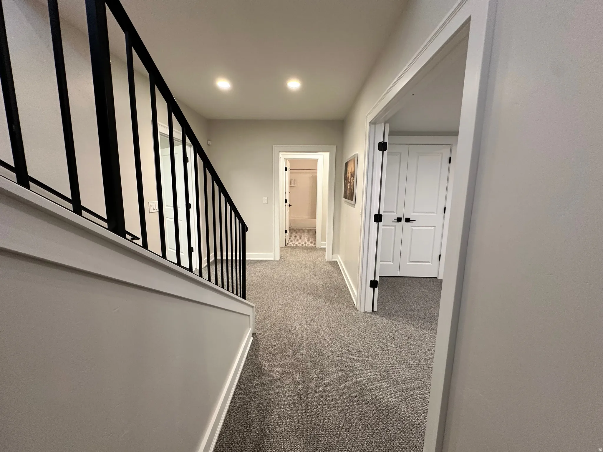 Hallway with light carpet and stairway