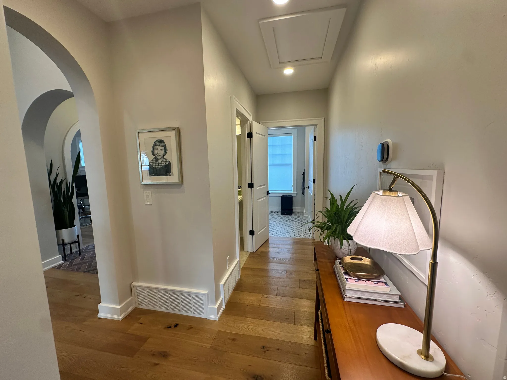 Corridor featuring hardwood / wood-style flooring, arched walkways, and recessed lighting