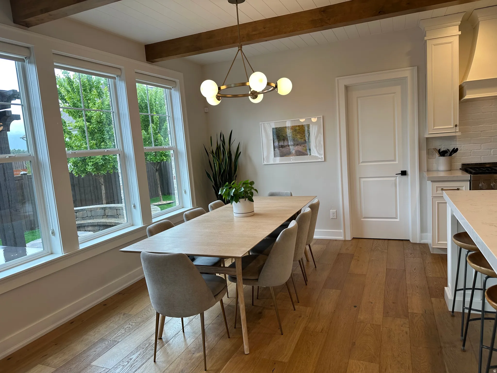 Dining area with dark wood-type flooring, suspended lighting, and beamed ceiling