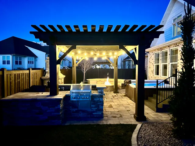 Fenced backyard with a pergola, Hot Tub, BBQ, a patio, an outdoor fire pit, and exterior kitchen