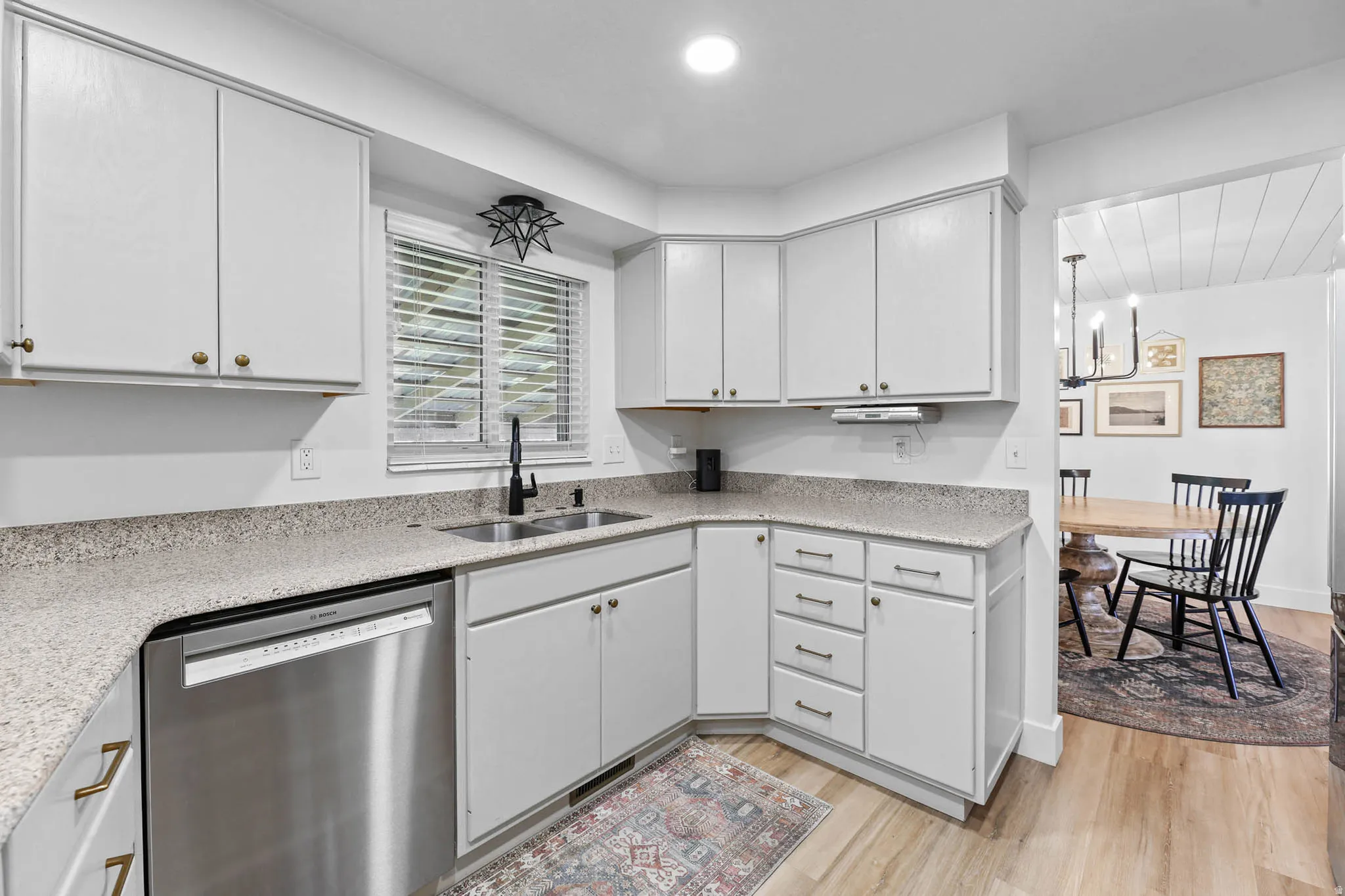 Kitchen with dishwasher, light wood-style flooring, light stone counters, recessed lighting, and white cabinetry