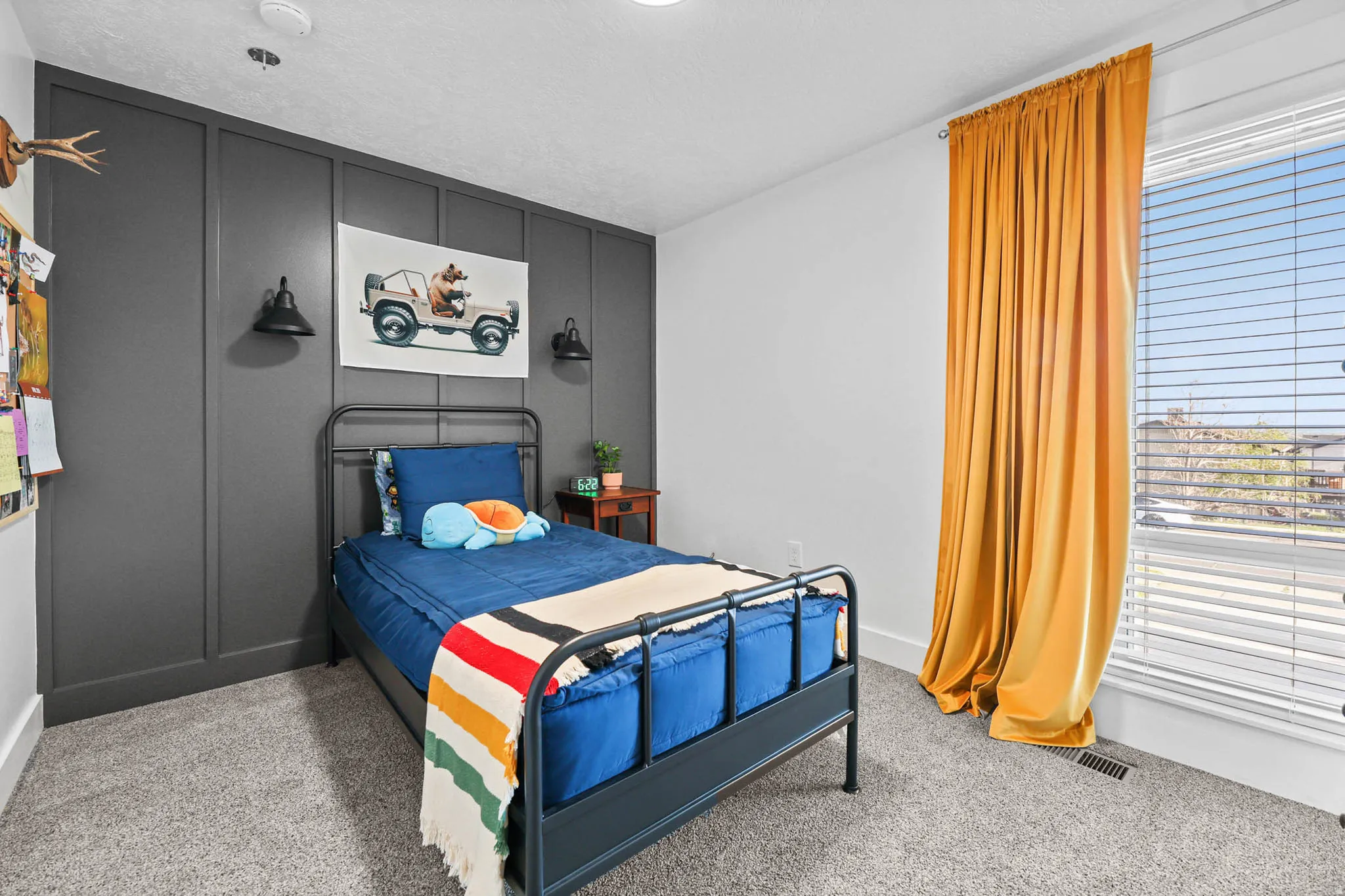 Bedroom featuring a decorative wall and light carpet