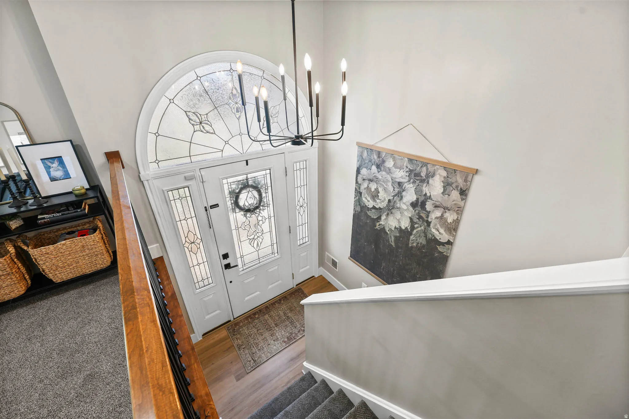 Foyer with suspended lighting, dark wood-style flooring, and a high ceiling
