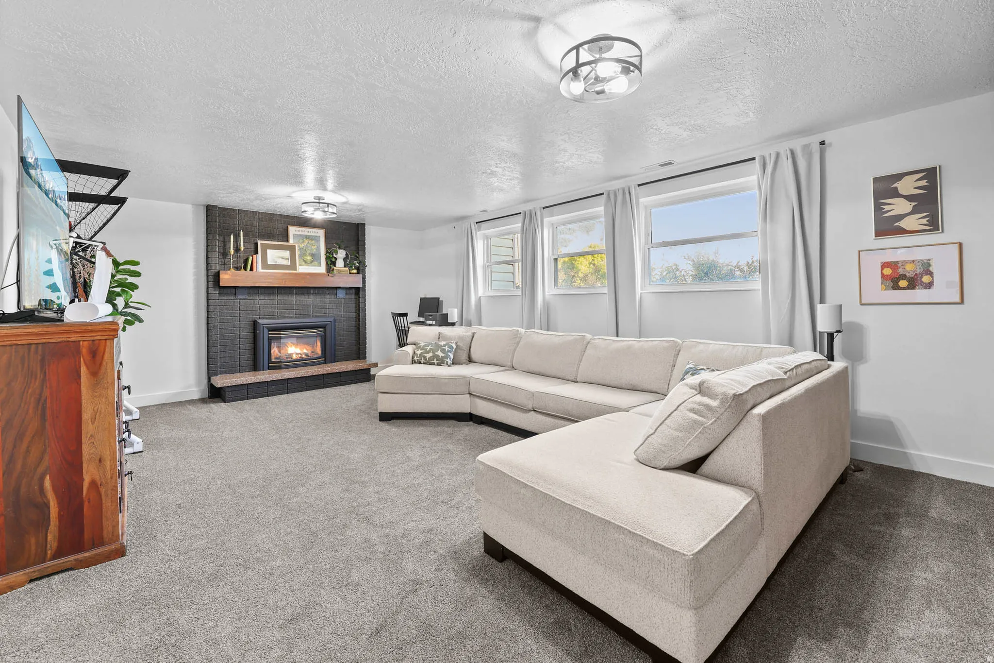 Carpeted living room featuring a fireplace and a textured ceiling