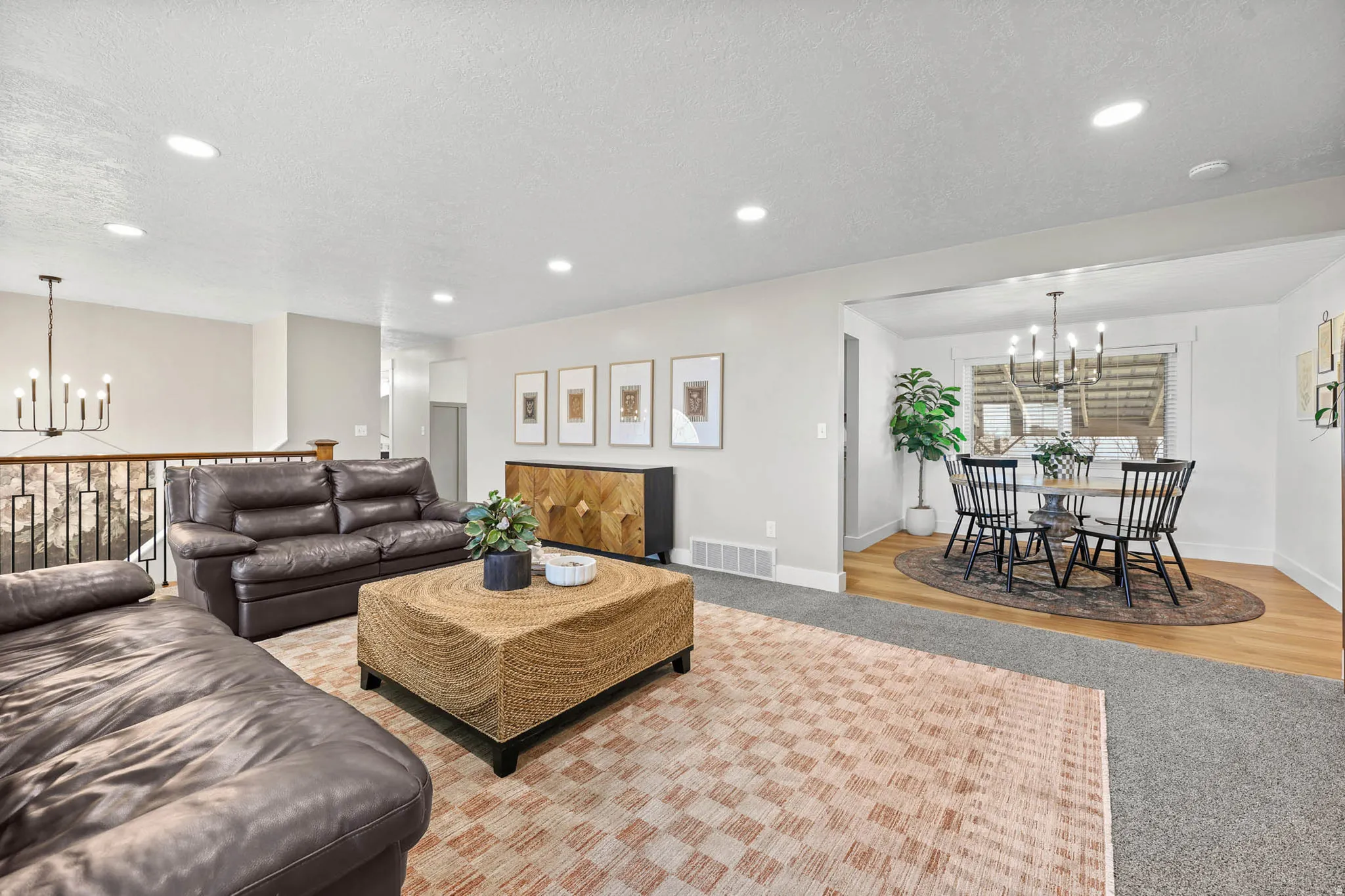 Living area with hanging lights, light colored carpet, and a textured ceiling