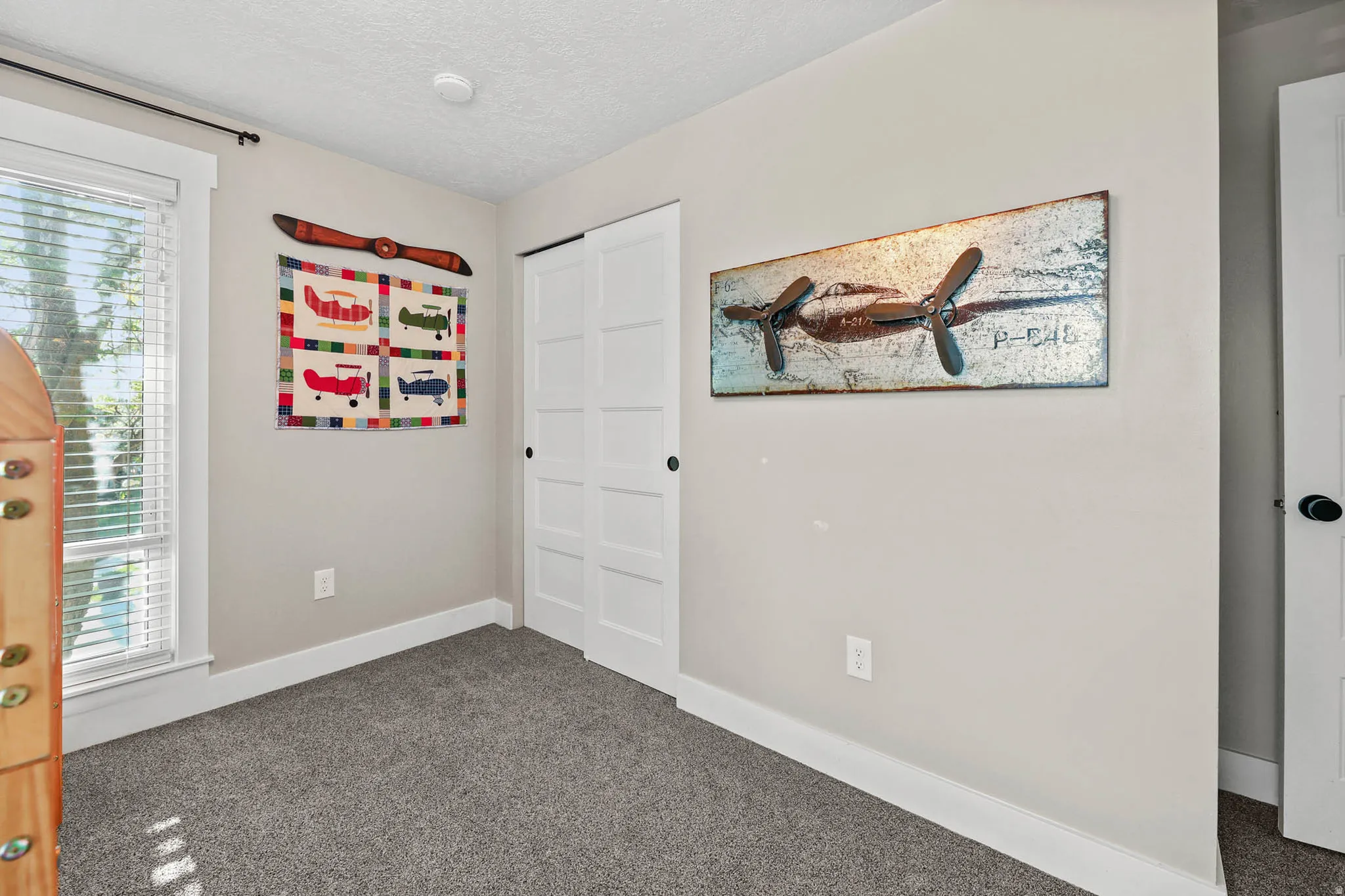 Unfurnished bedroom with dark colored carpet, a closet, and a textured ceiling