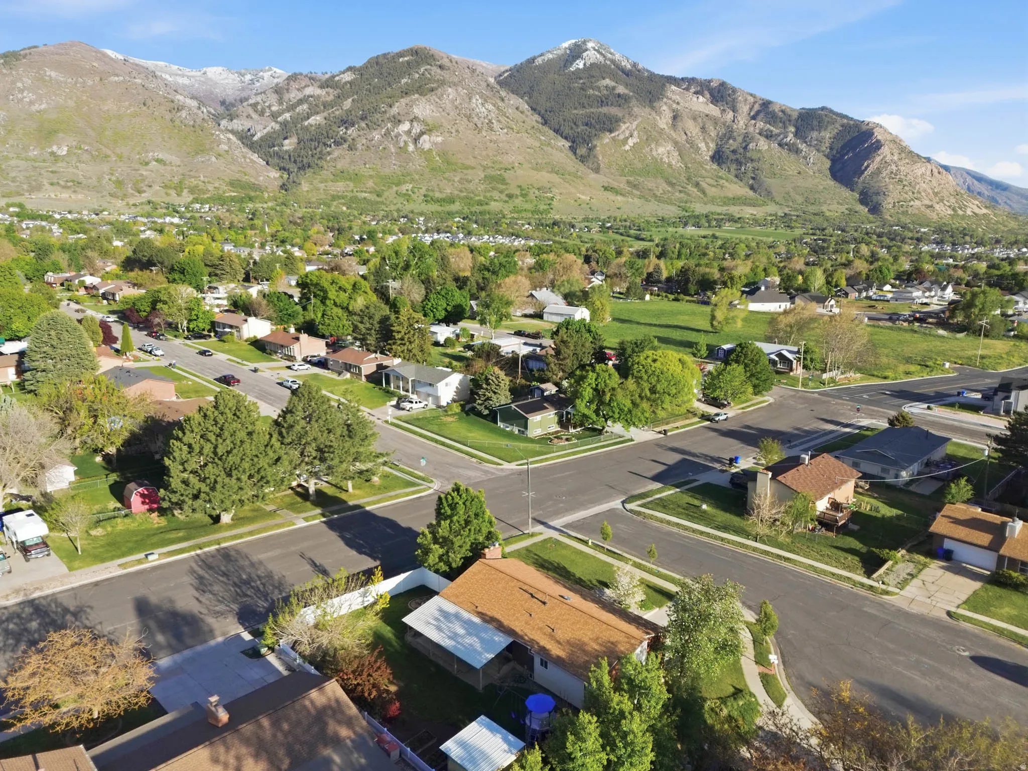 Aerial view of property and surrounding area with a mountainous background and nearby suburban area