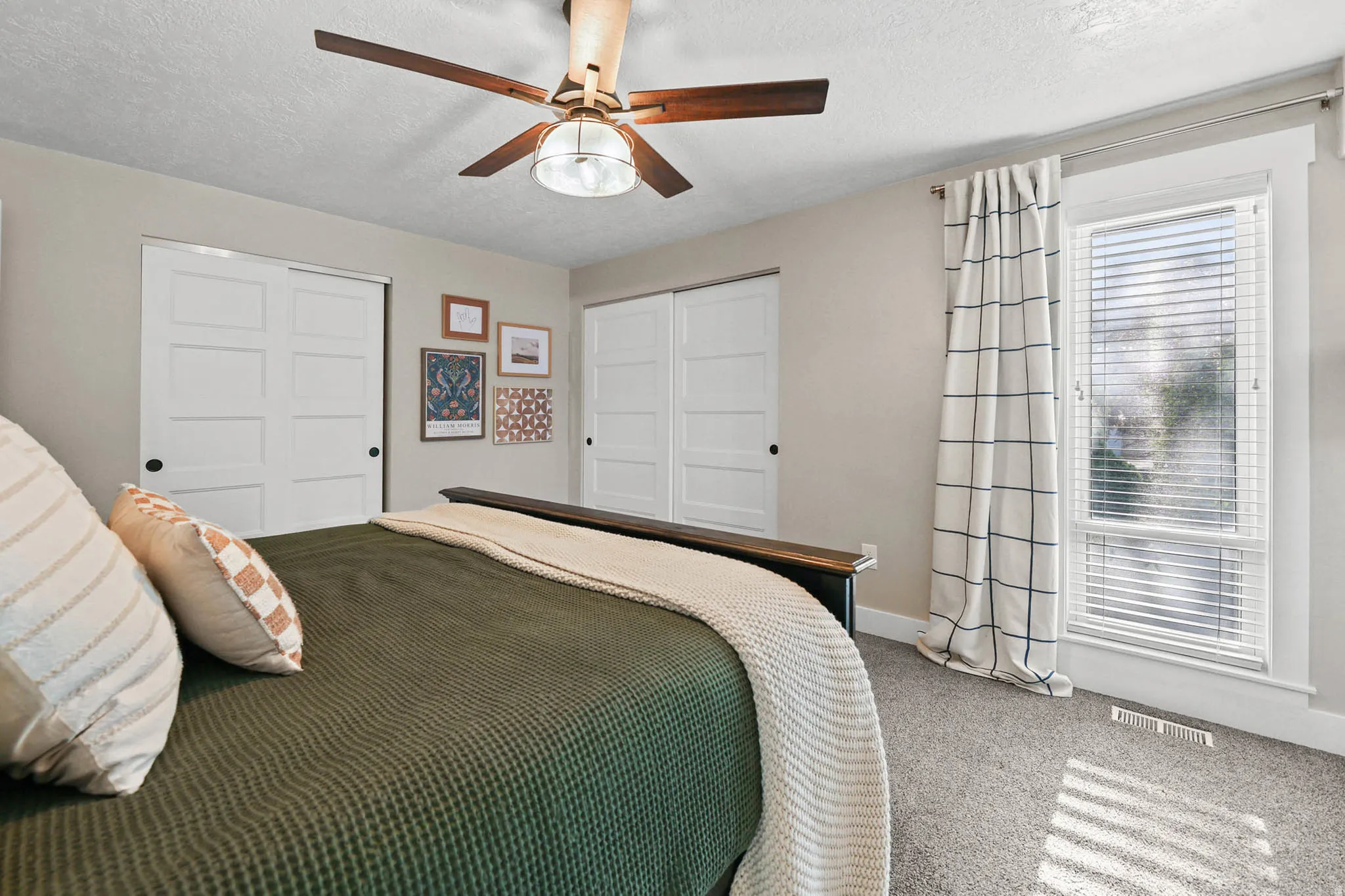 Bedroom with a closet, carpet floors, a textured ceiling, and a ceiling fan