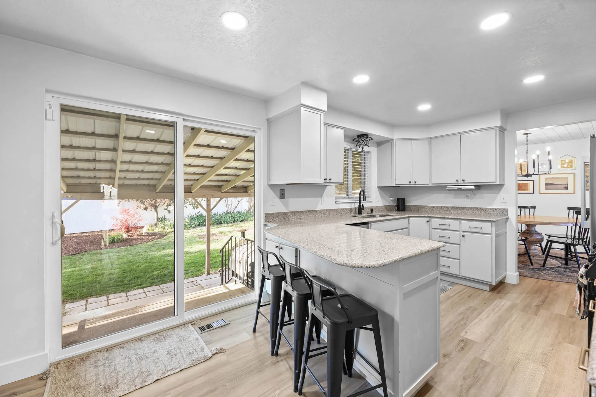 Kitchen with a peninsula, a breakfast bar area, and light wood-type flooring