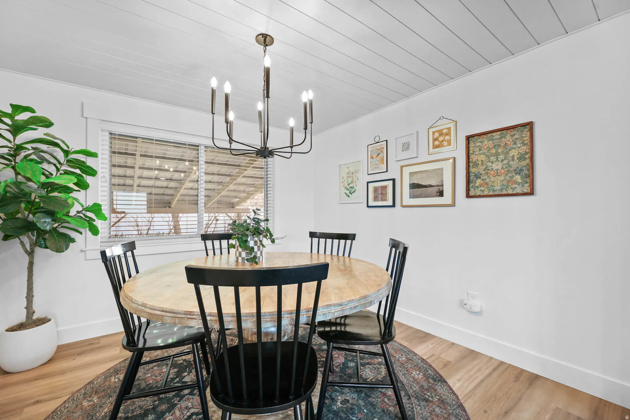 Dining room featuring wood ceiling, light wood-type flooring, and suspended lighting