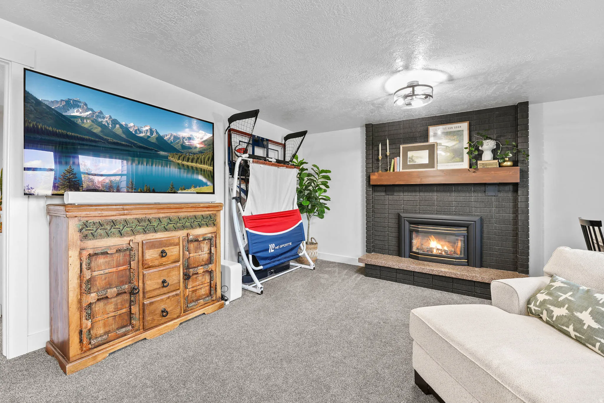 Living area with carpet, a fireplace, and a textured ceiling