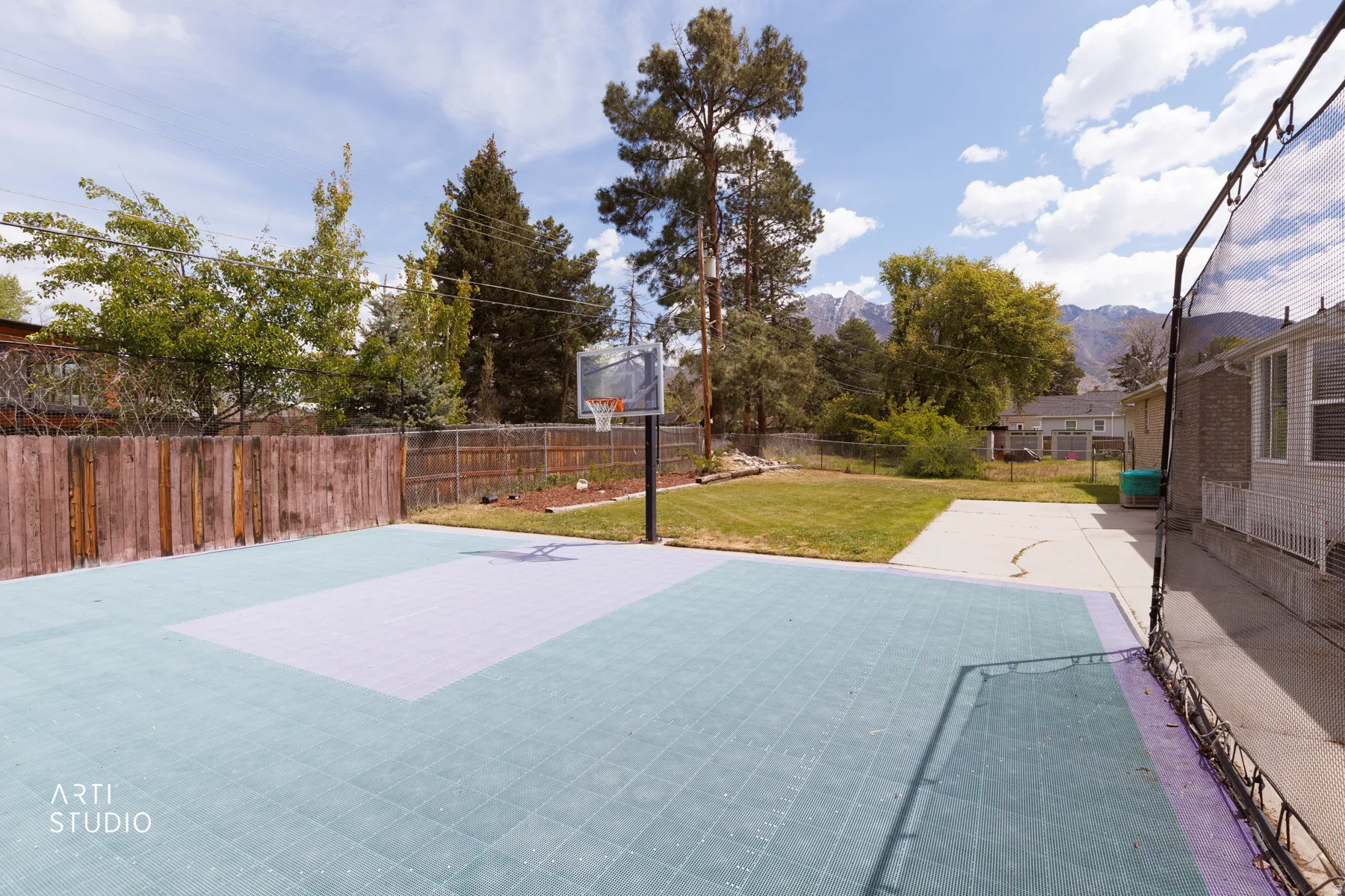 View of basketball court with a fenced backyard and basketball court
