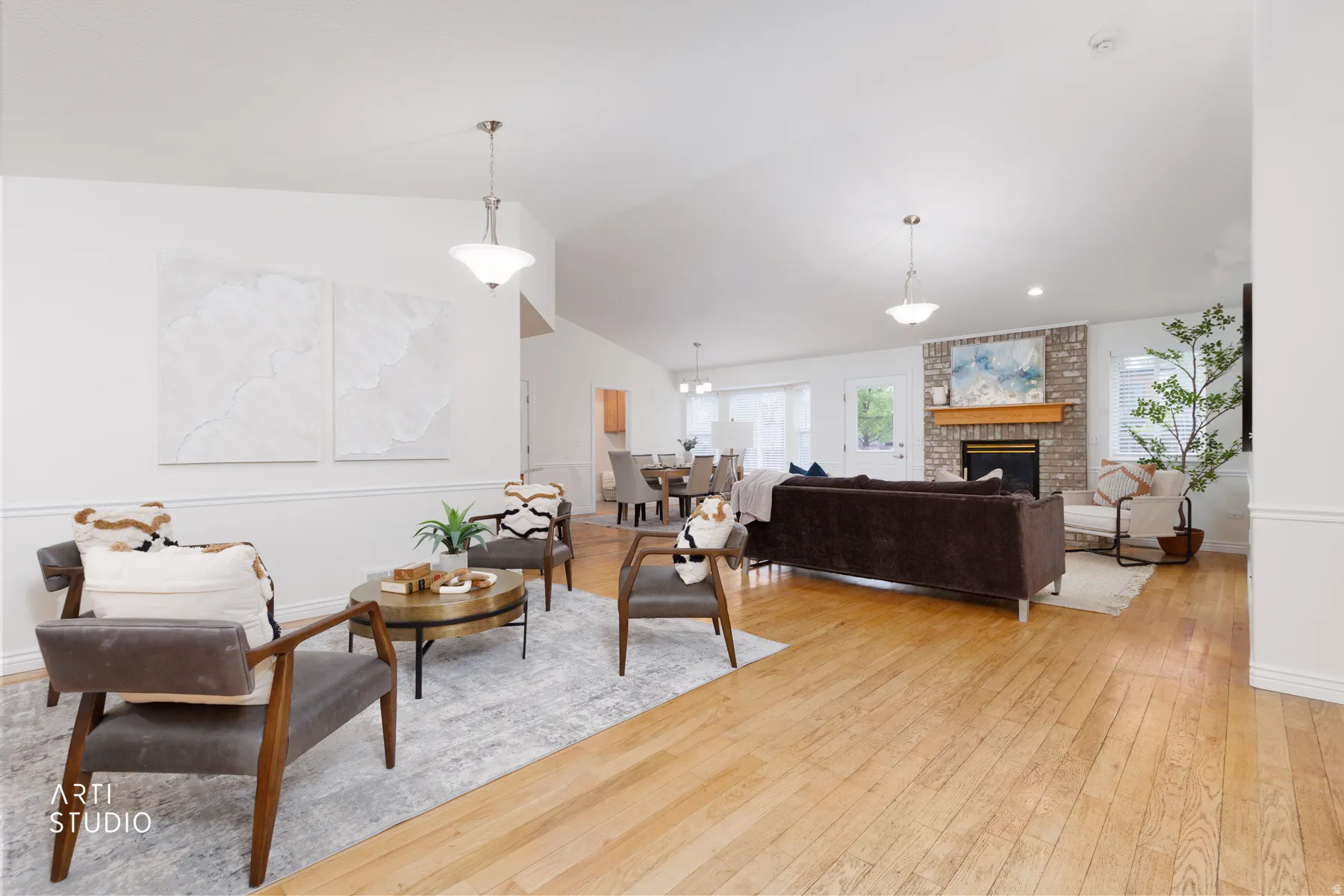 Living room featuring light wood-type flooring, a fireplace, and vaulted ceiling