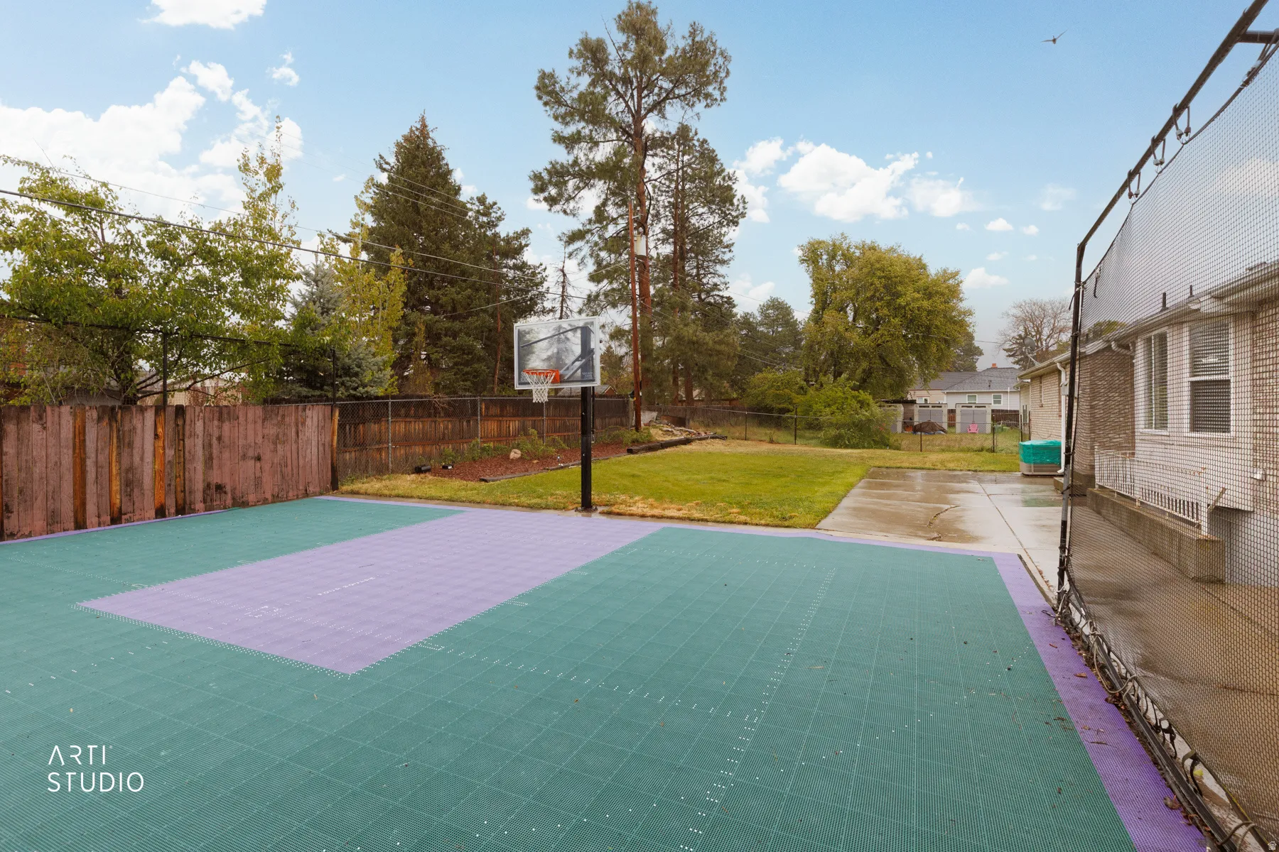 View of sport court with a fenced backyard and basketball hoop