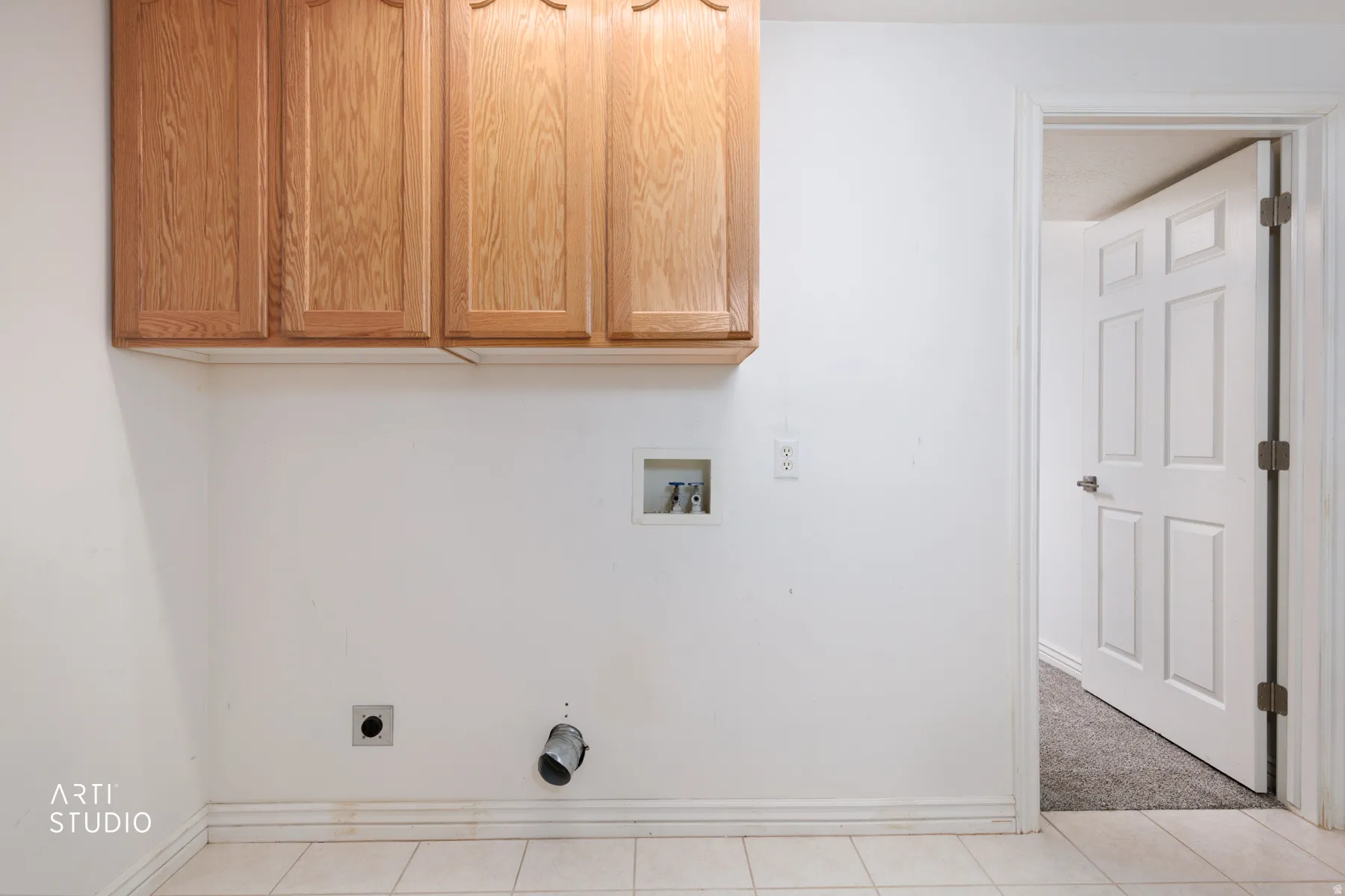 Laundry area featuring hookup for an electric dryer, cabinet space, hookup for a washing machine, light colored carpet, and light tile patterned floors