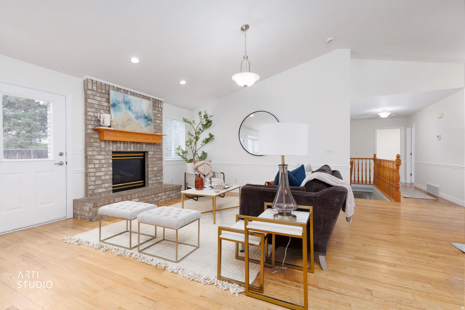 Living area featuring light wood-type flooring, vaulted ceiling, a brick fireplace, and recessed lighting