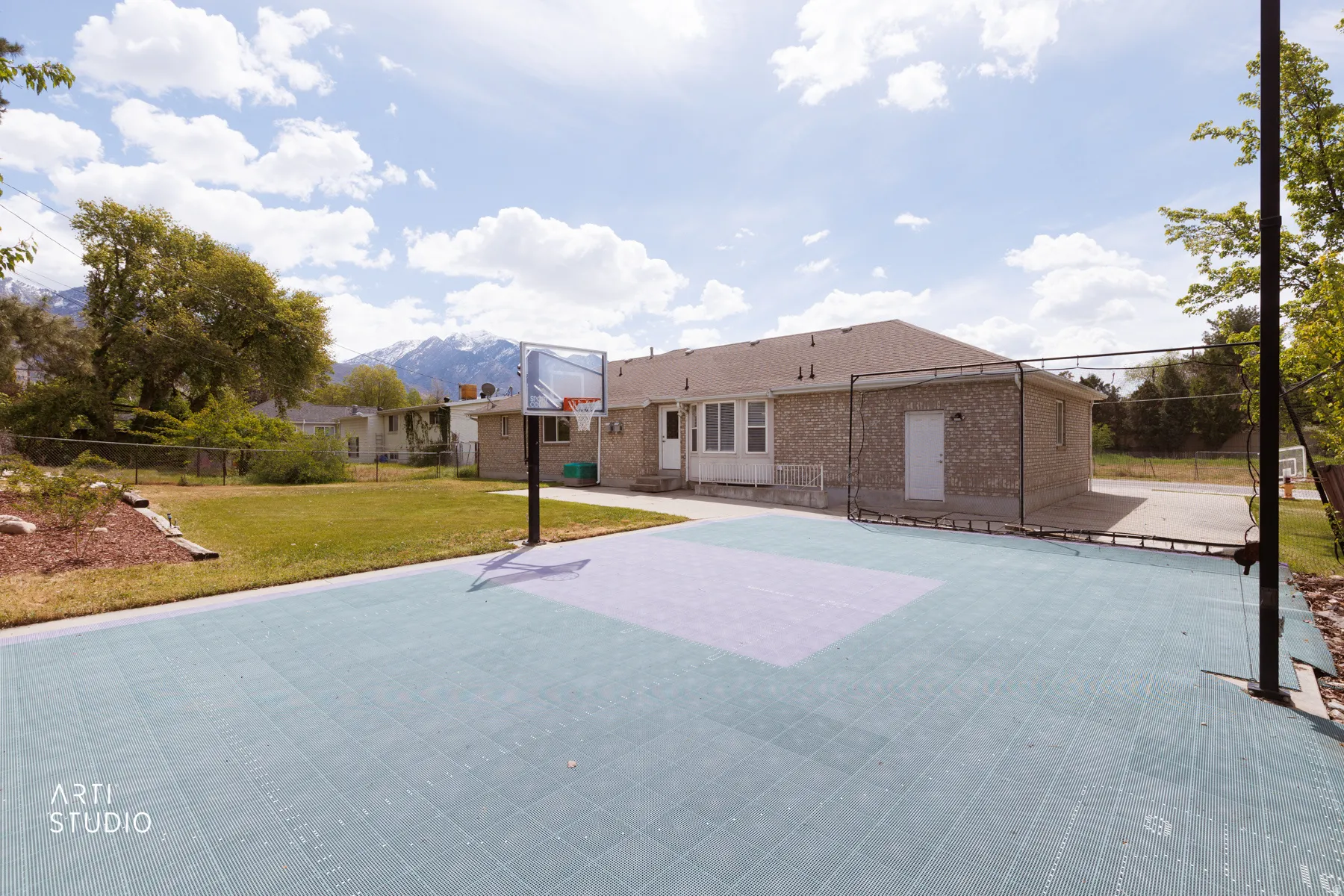 View of sport court featuring a mountain view and basketball hoop