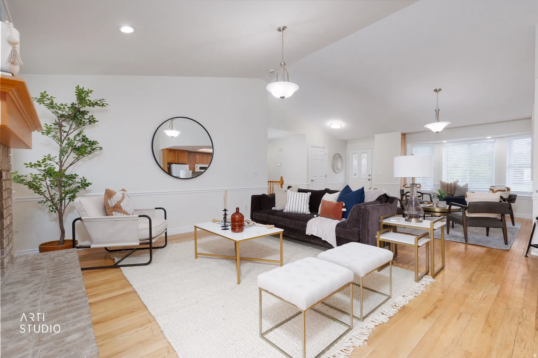 Living area featuring light wood finished floors, vaulted ceiling, and a fireplace