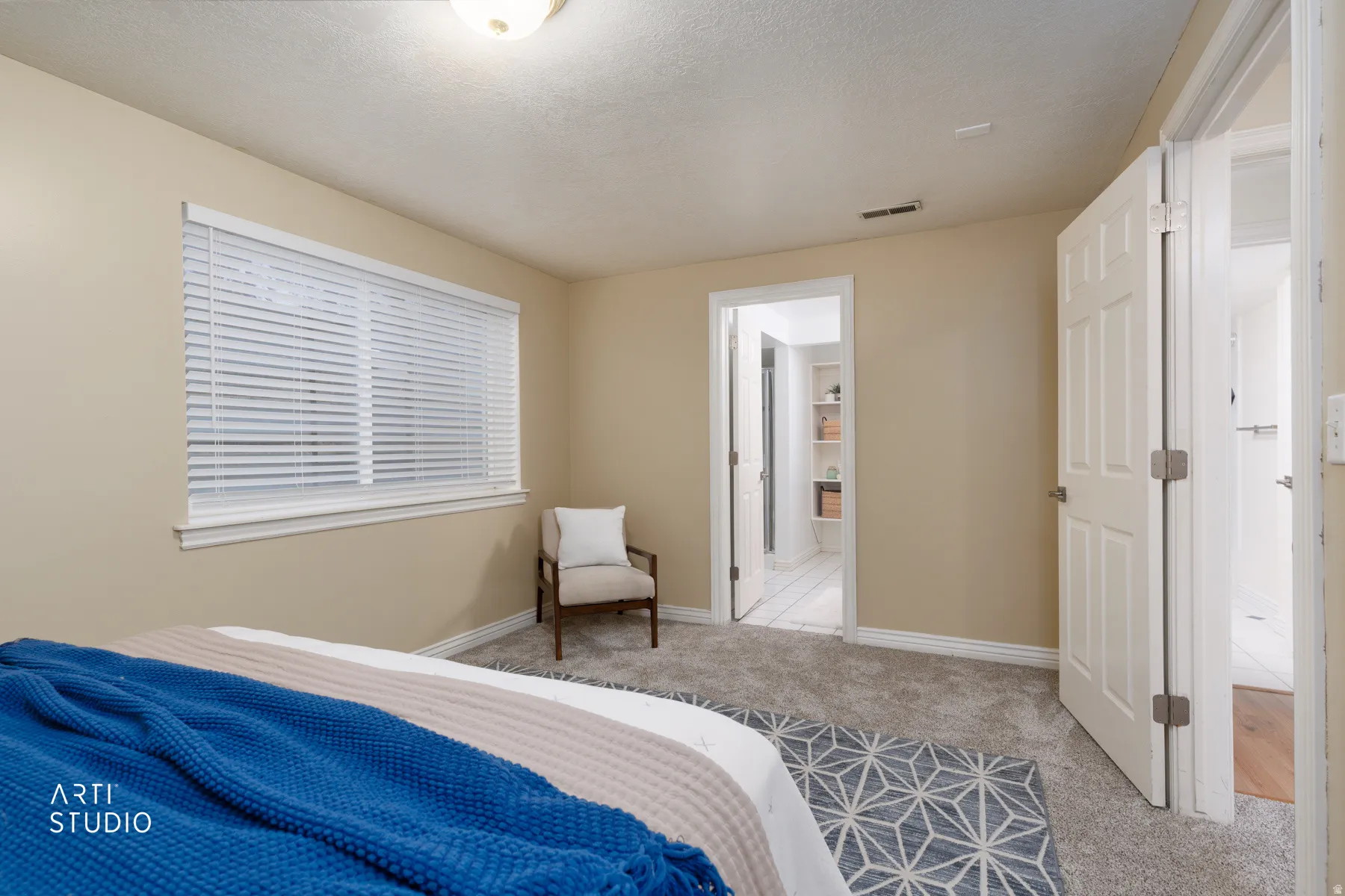Bedroom featuring light carpet and a textured ceiling