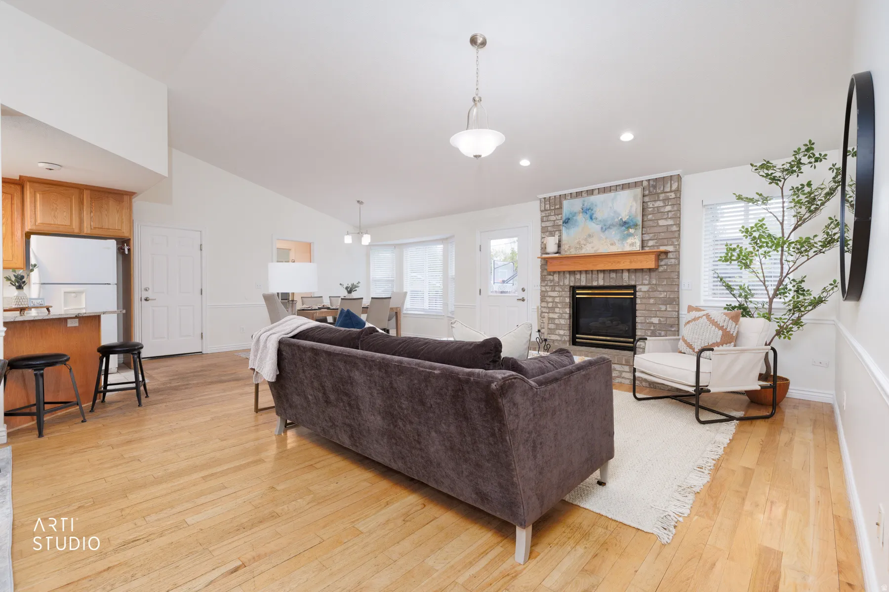 Living area featuring light wood-type flooring, lofted ceiling, a fireplace, and recessed lighting
