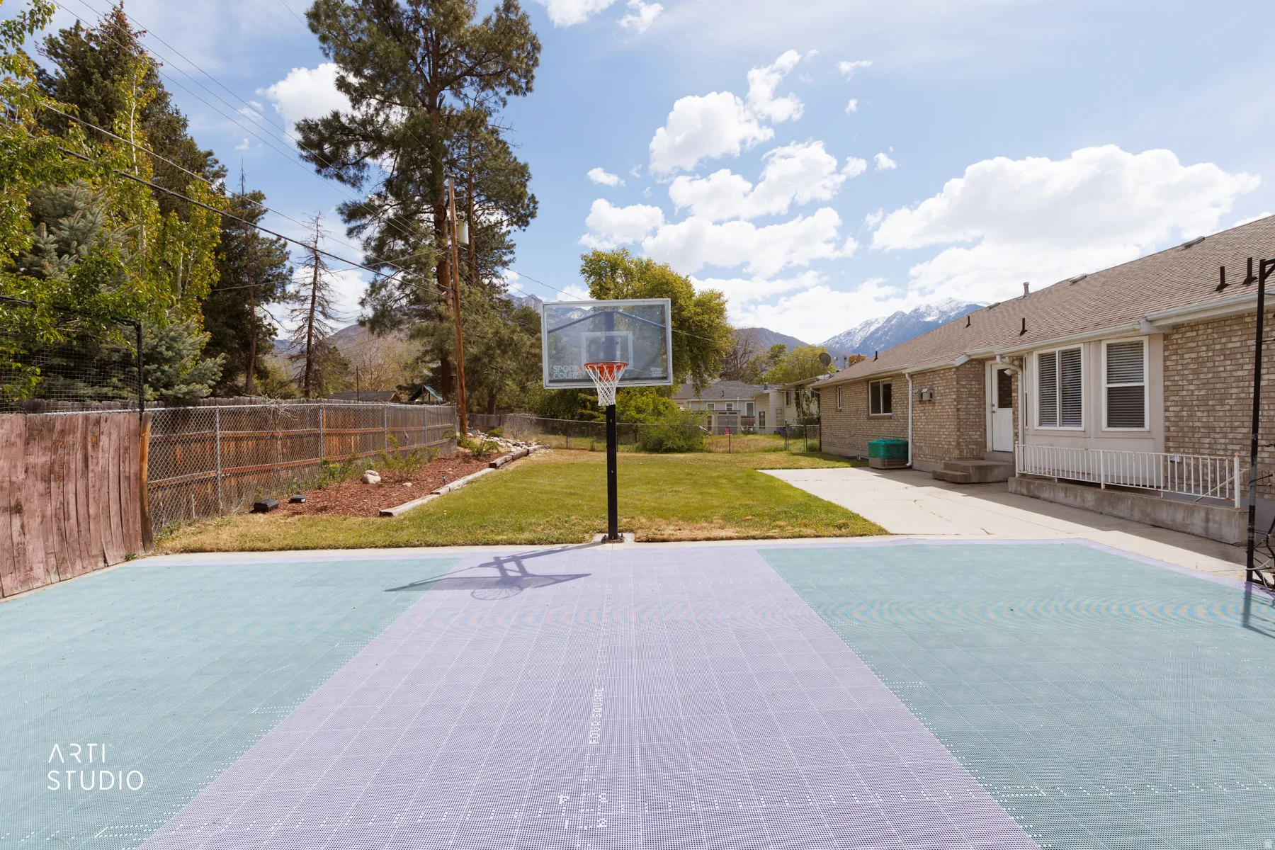View of basketball court featuring a patio area, a fenced backyard, basketball court, and a mountain view