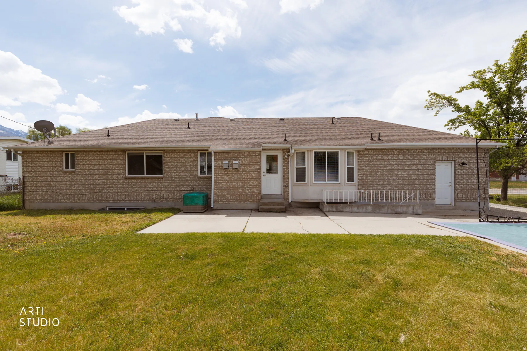 Back of property featuring a patio, brick siding, and a lawn