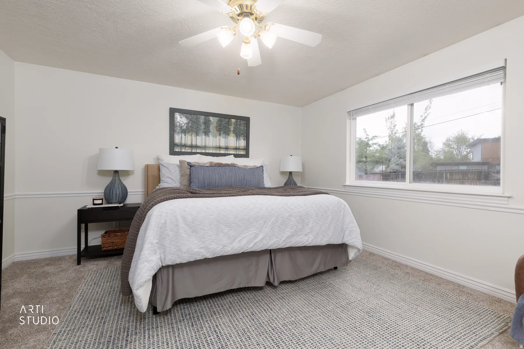 Bedroom featuring light carpet, ceiling fan, and a textured ceiling