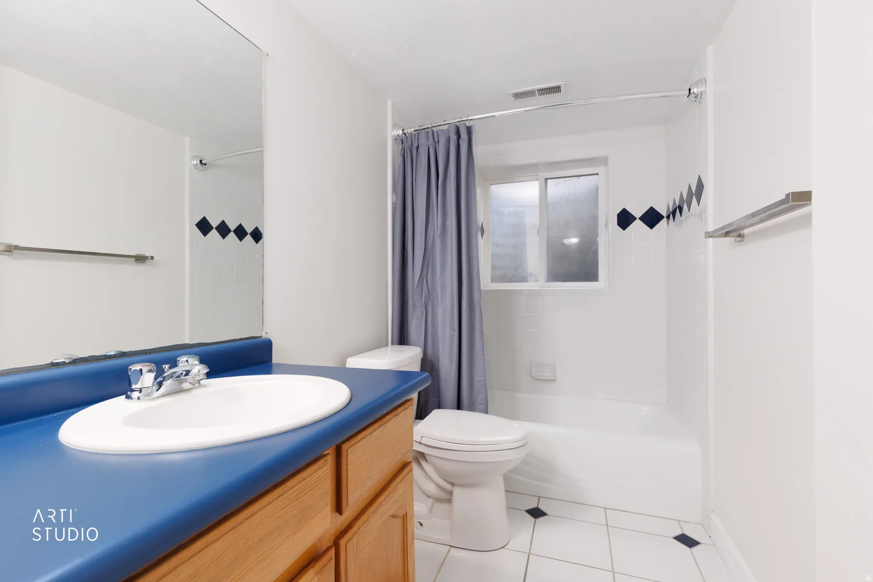 Full bathroom with vanity, light tile patterned floors, and shower / bathtub combination with curtain