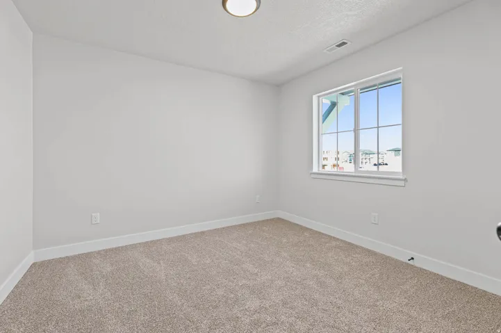 Carpeted spare room featuring baseboards and a textured ceiling