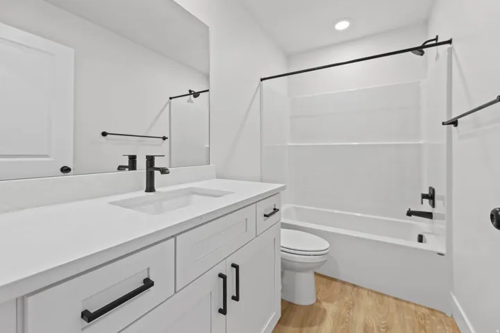 Bathroom featuring light wood-style flooring, vanity, and tub / shower combination