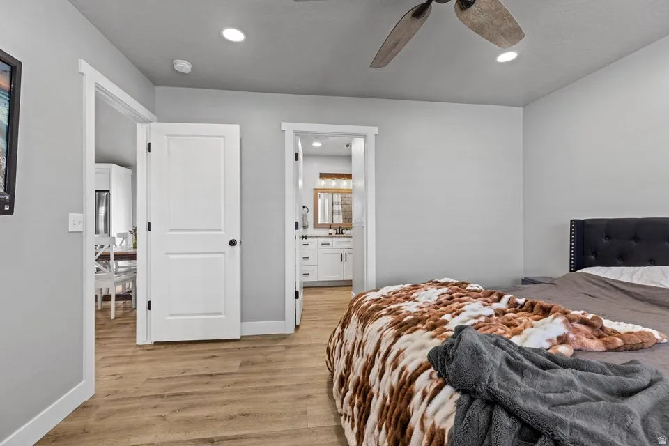 Bedroom featuring light wood finished floors, recessed lighting, ensuite bathroom, and a ceiling fan