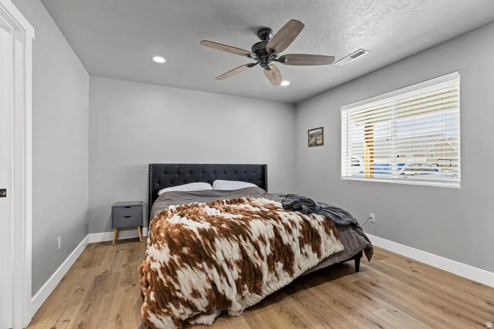 Bedroom featuring light wood-style flooring, a ceiling fan, and recessed lighting