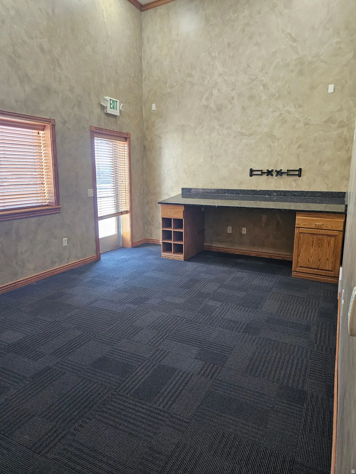 Spacious room featuring high ceilings and textured wall finishes