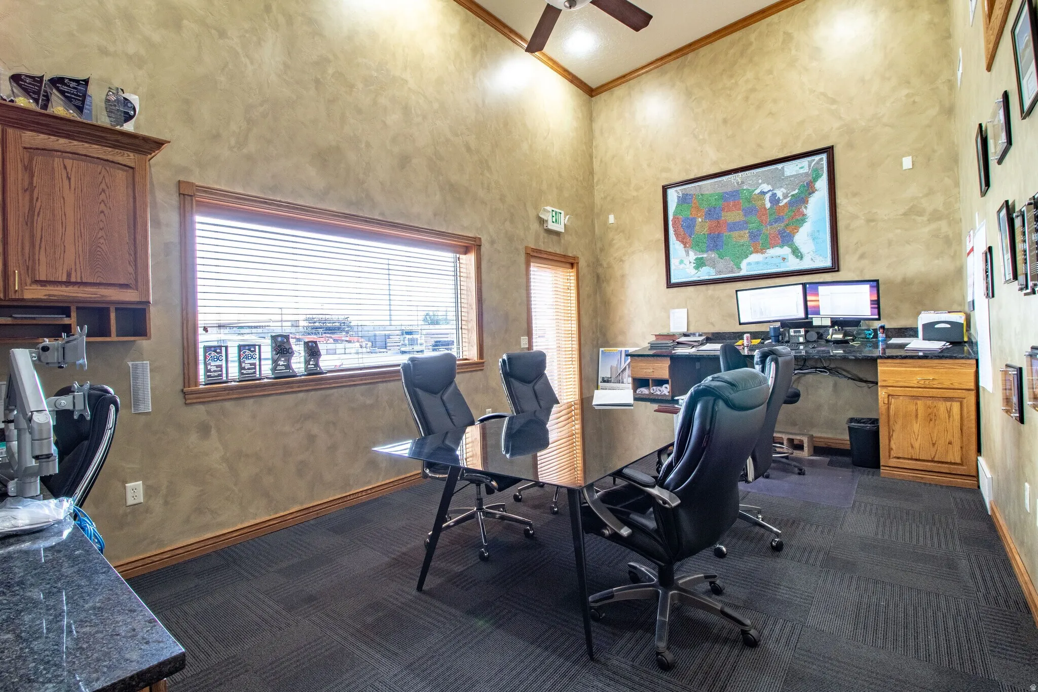 Office area with a high ceiling, ornamental molding, and a ceiling fan