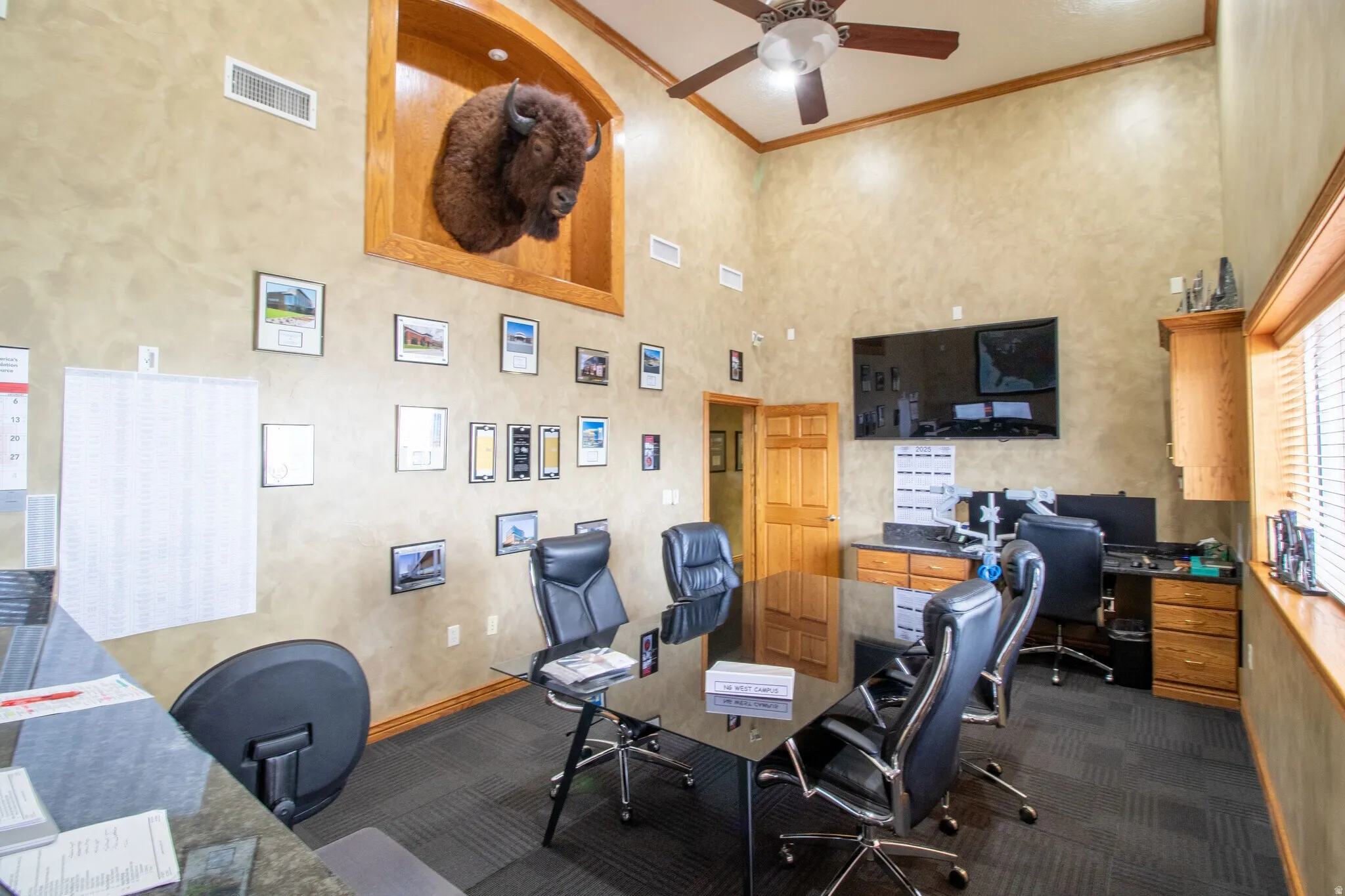 Home office featuring ornamental molding, a ceiling fan, and a high ceiling