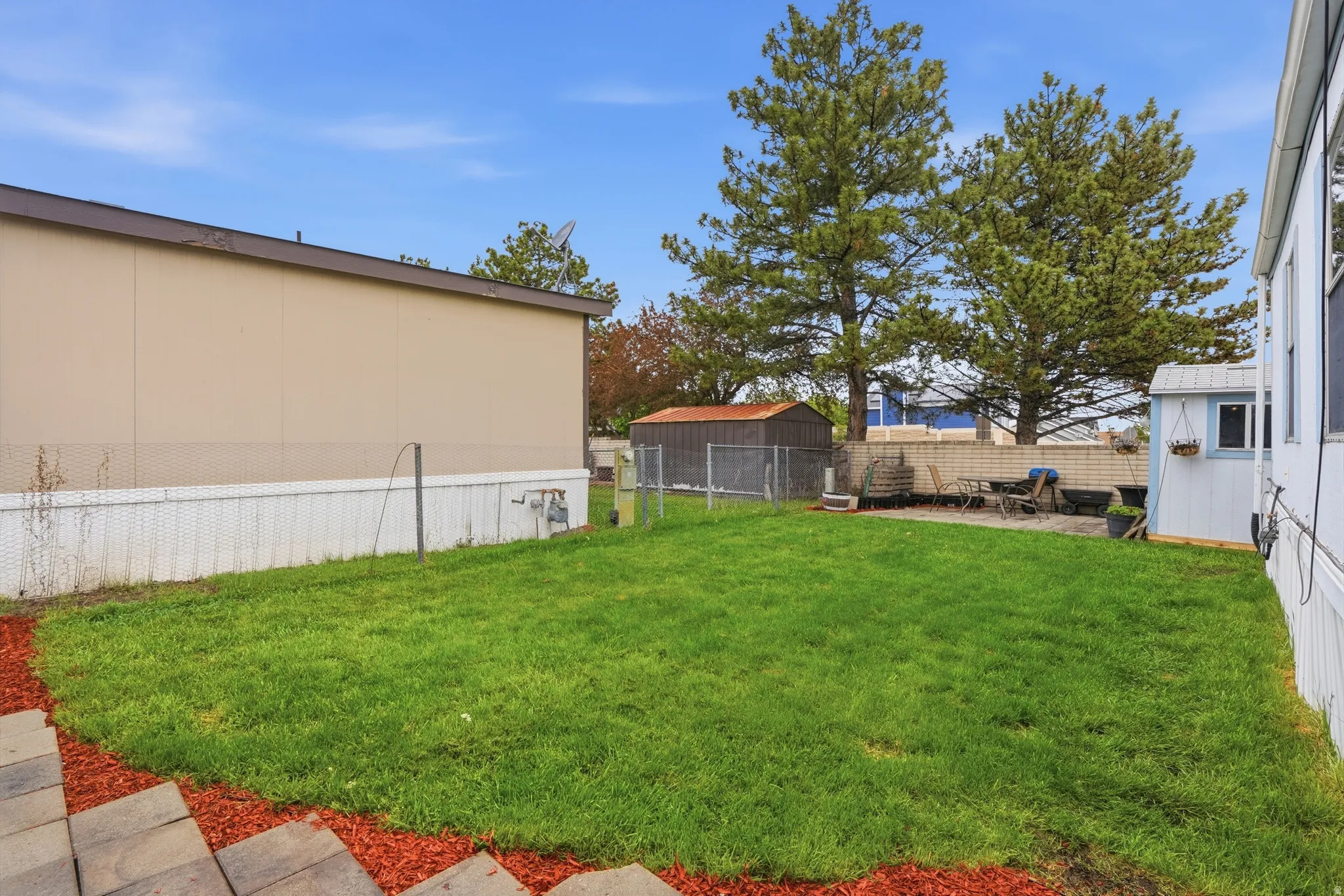 Fenced backyard featuring a patio and an outbuilding