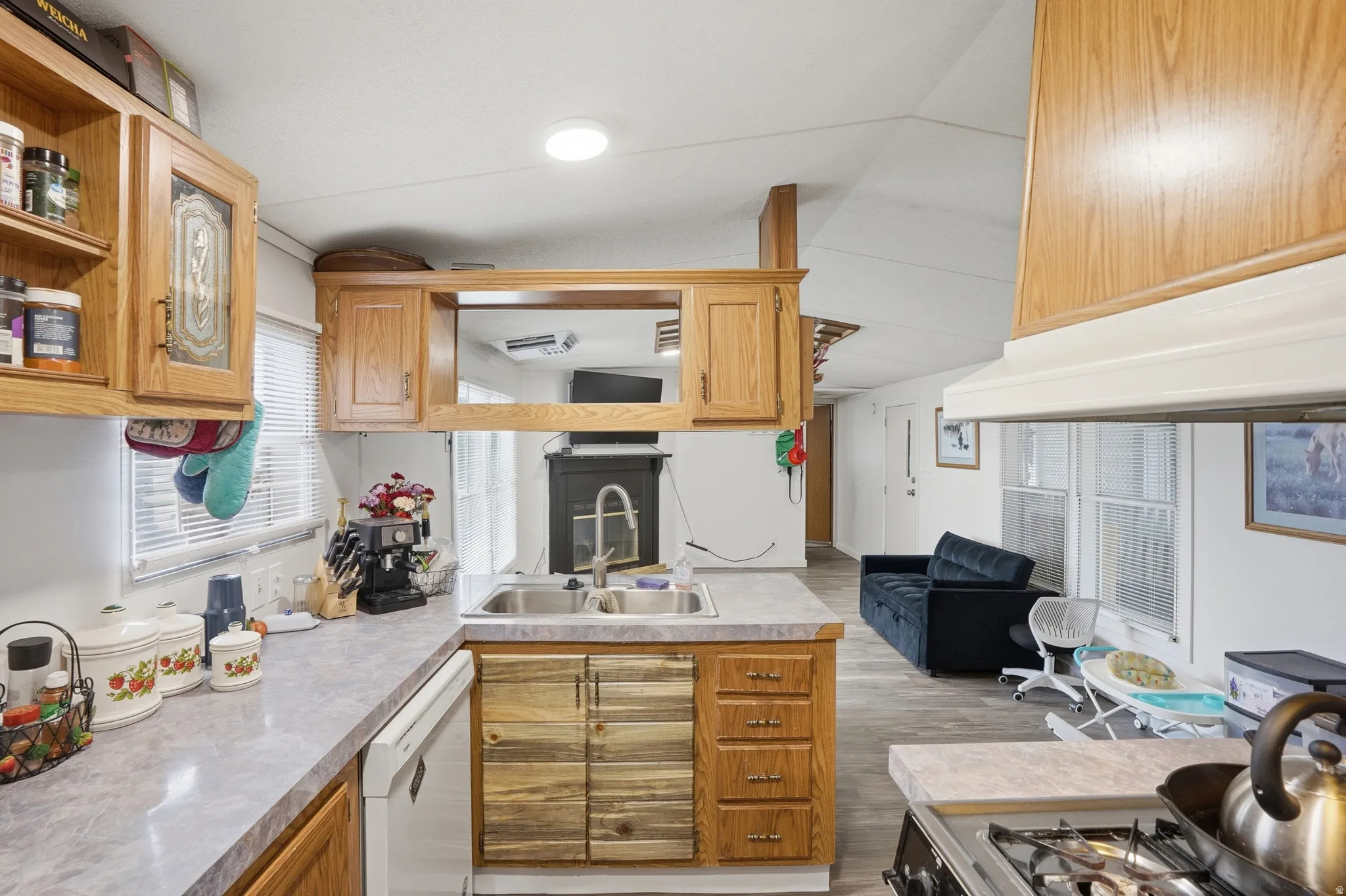 Kitchen with light countertops, dishwasher, open shelves, light wood-style floors, and recessed lighting