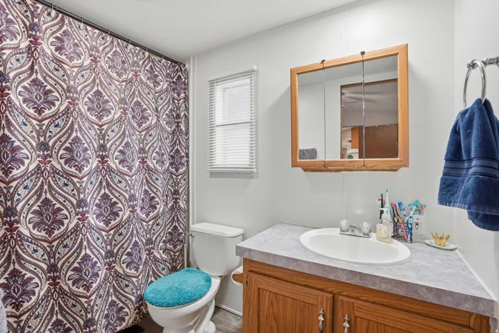 Full bath featuring vanity and curtained shower