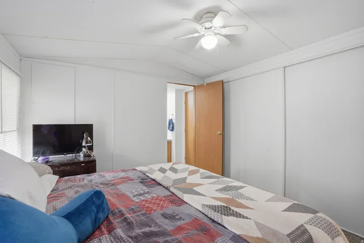 Bedroom featuring lofted ceiling, a ceiling fan, and a closet
