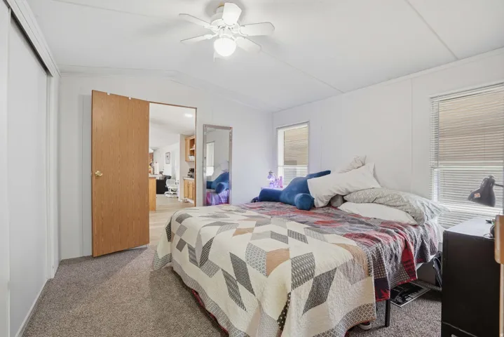 Carpeted bedroom featuring ceiling fan