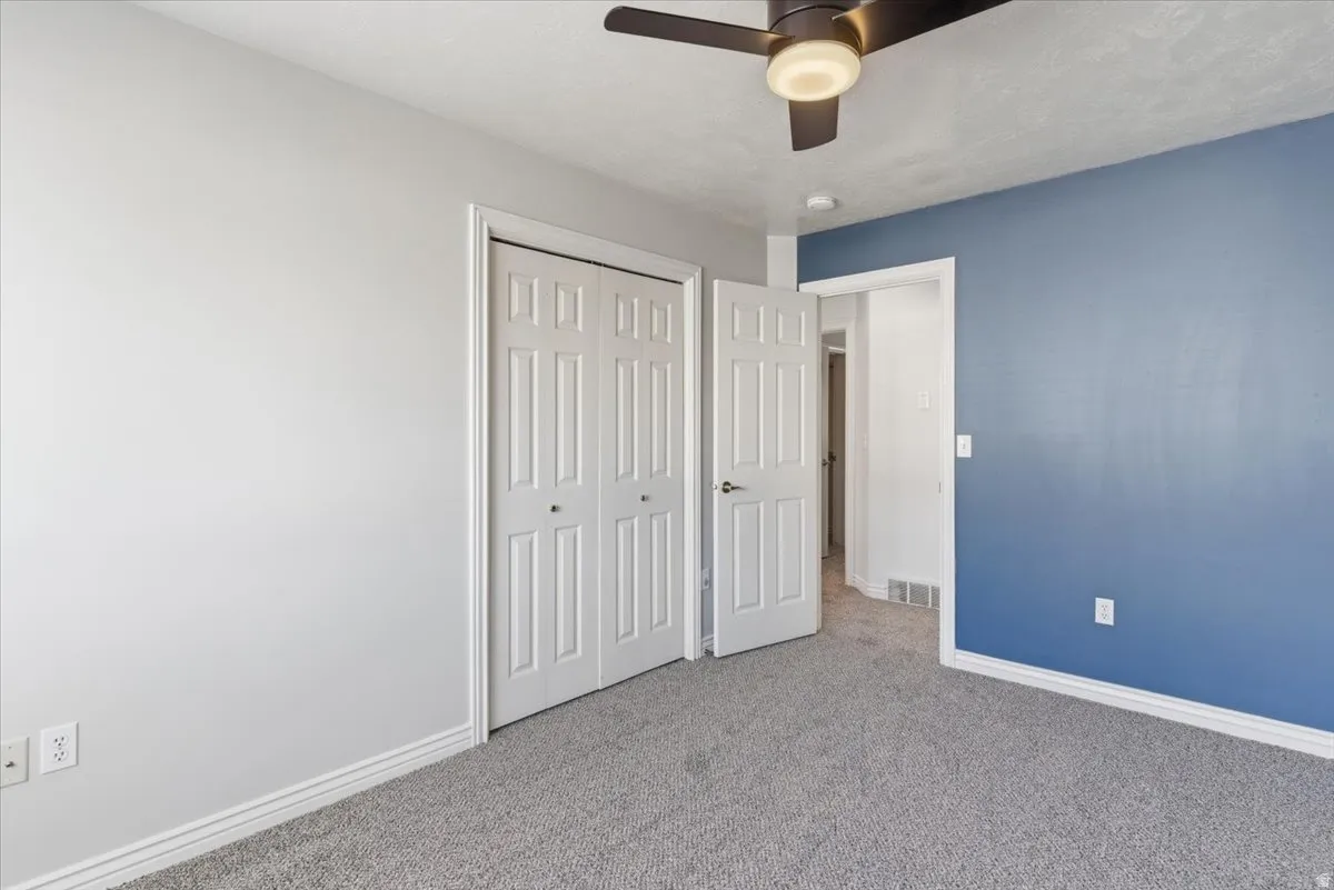 Unfurnished bedroom with carpet flooring, a closet, and a ceiling fan