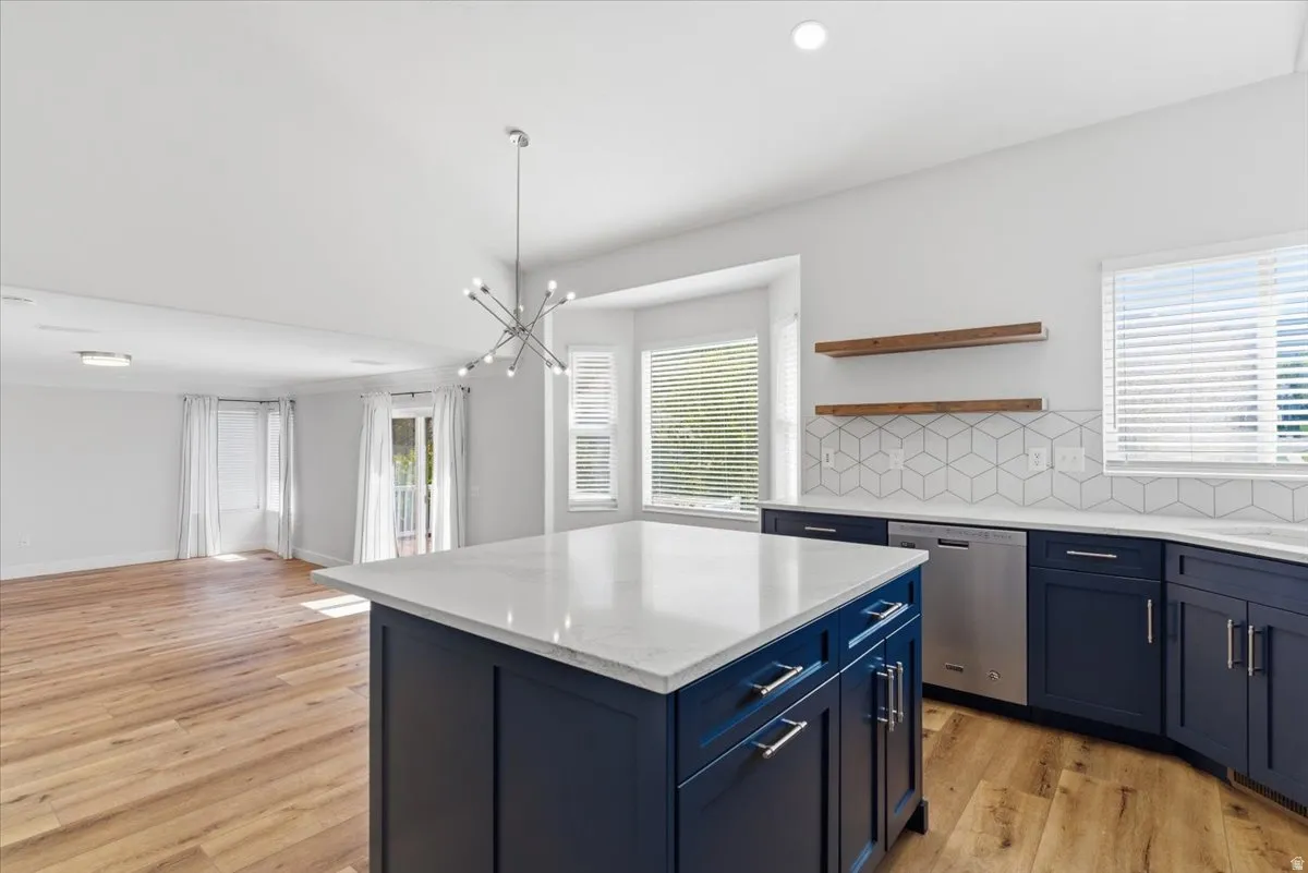 Kitchen featuring decorative backsplash, a kitchen island, open shelves, and plenty of natural light