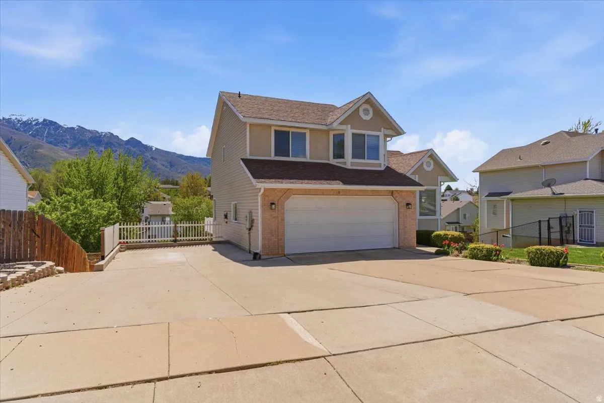Traditional-style home featuring driveway, an attached garage, a shingled roof, and a mountain view