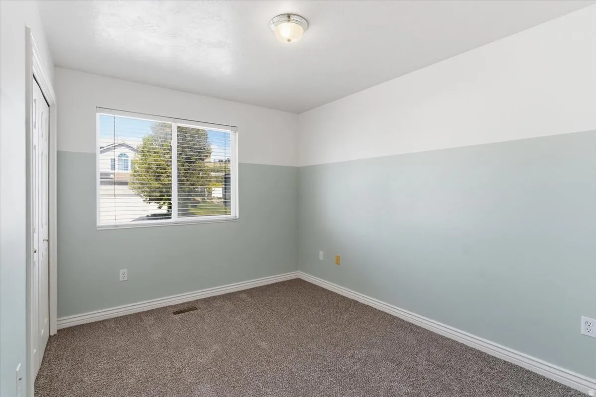 Unfurnished bedroom with a closet and dark carpet