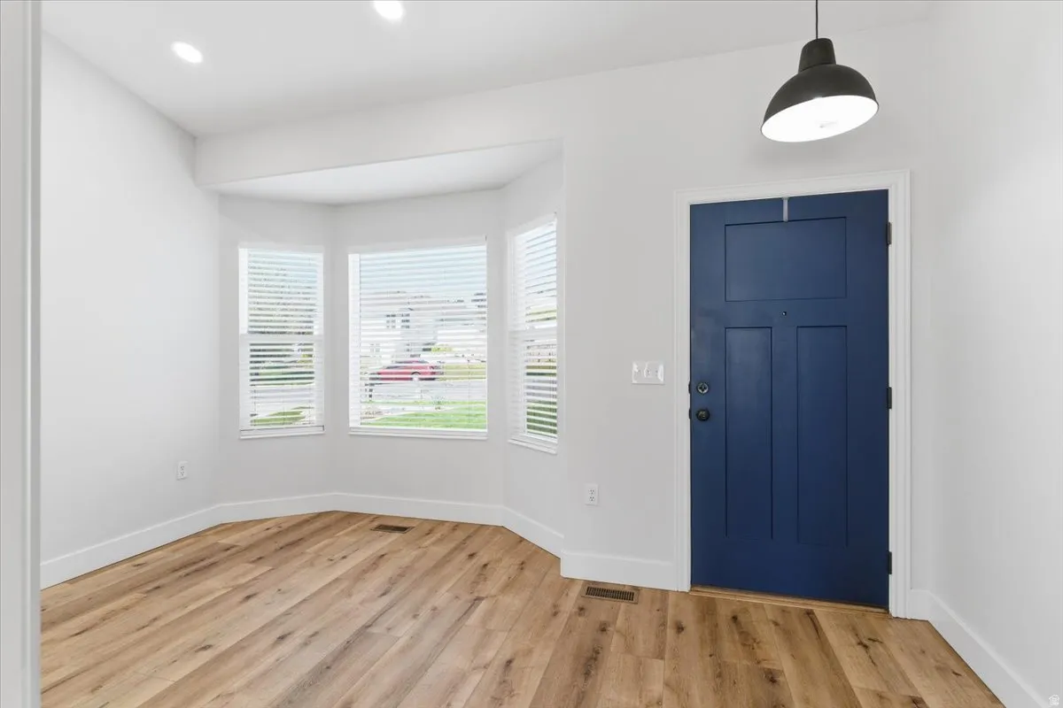 Foyer with light wood-style flooring and recessed lighting